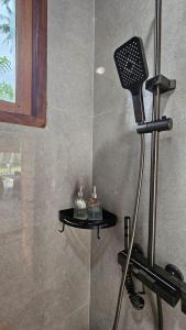 a shower with a hair dryer in a bathroom at Island Time Surf Resort in Lasikin