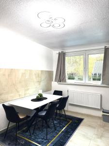 a dining room with a white table and chairs at MIO Apartments Sulzbach in Schnappach