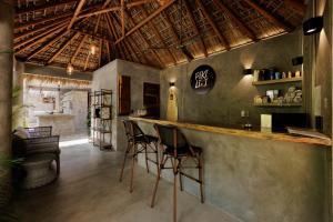 a bar with stools in a room with a kitchen at Hotel Boutique Pikiliki - ADULTS ONLY in Brisas de Zicatela