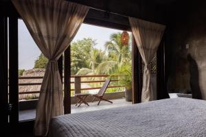 a bedroom with a bed and a view of a balcony at Hotel Boutique Pikiliki - ADULTS ONLY in Brisas de Zicatela