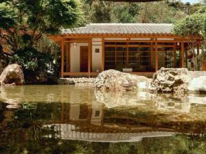 a building with a pond in front of a house at GO 255 Residencial c/ Piscina, Academia e Jacuzzi in Poços de Caldas