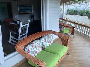 a porch with a wicker chair and a couch at Tropical Landhouse in Sánchez