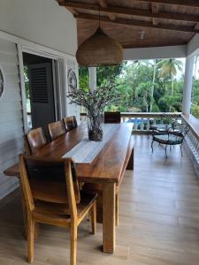 a wooden dining room table and chairs on a porch at Tropical Landhouse in Sánchez