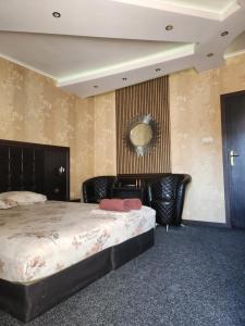a bedroom with a bed and a mirror on the wall at Hotel Chamishki in Blagoevgrad