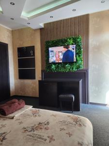 a living room with a tv on a wall at Hotel Chamishki in Blagoevgrad