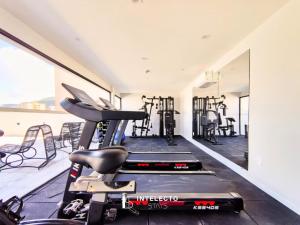 an exercise room with a treadmill and a gym at GO 255 Residencial c/ Piscina, Academia e Jacuzzi in Poços de Caldas