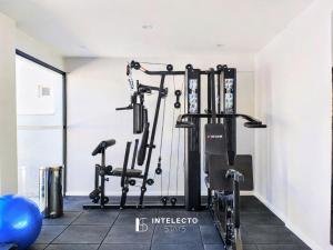 a gym with two treadmills and weights at GO 255 Residencial c/ Piscina, Academia e Jacuzzi in Poços de Caldas
