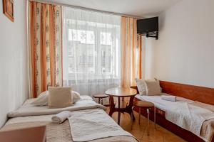a room with two beds and a table and a window at Natural Mielno in Mielno