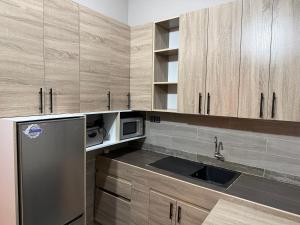 a kitchen with a stainless steel refrigerator and a microwave at Appartement Kekely in Yovo Kopé