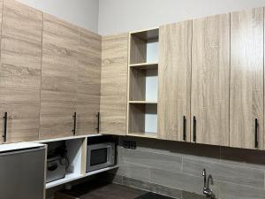 a kitchen with wooden cabinets and a microwave at Appartement Kekely in Yovo Kopé +20 photos