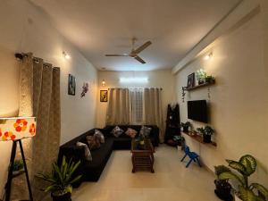 a living room with a couch and a tv at Hazel's ELiTE Homestay 2bhk in Mysore