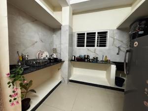 a small kitchen with a counter in a room at Hazel's ELiTE Homestay 2bhk in Mysore