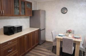 a kitchen with a table and a stainless steel refrigerator at Apartman Centar 1 in Šabac
