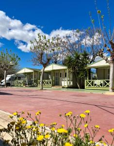 a building with yellow flowers in front of it at Camping El Jardín in El Campello