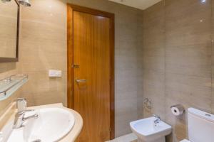 バルセロナにあるApartEasy - Family Apartment Sant Antoniのバスルーム(洗面台、トイレ付)、木製のドアが備わります。