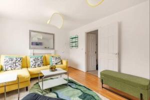 a living room with a yellow couch and a table at Spacious 4-Bed Home with Workspace in Coundon