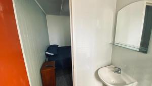 a small bathroom with a sink and a mirror at Hostal Santa Sabina in Concepción