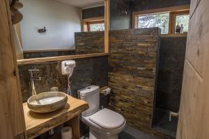a bathroom with a sink and a toilet in a room at Casa Bosque Chiloé in Dalcahue