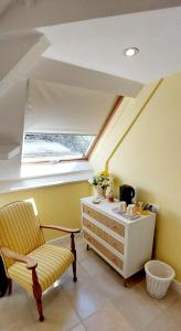 a room with a chair and a dresser and a window at Le Verger Chambres d'hotes in Ségur-le-Château