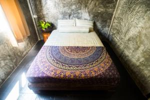 a bedroom with a bed with a blanket on it at Sweet Life Community Guesthouse in Ko Lanta