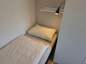 a small room with a bed and a light at ZON Bed by the Sea in Westkapelle +15 photos