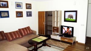 a living room with a couch and a tv at Nidos Poilsine Studio in Nida