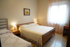 a hotel room with two beds and a window at Villa Erry in Trani