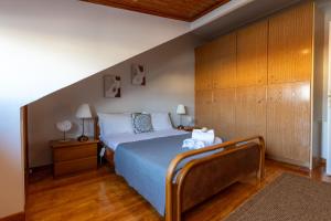 a bedroom with a bed and a wooden cabinet at Atticview Oropos in Néa Palátia +8 photos