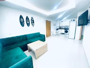a living room with a green couch and a coffee table at Sea & Pool View Apt 1 in Aourir
