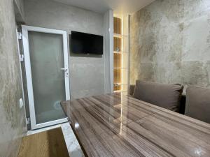 a dining room with a table and a tv on a wall at Апартаменти Studio Amur Creative in Khmelnytskyi