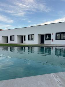 a white building with a swimming pool in front of it at Atrio Homes Sansueña in Córdoba