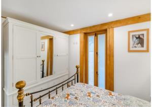 a bedroom with a bed and a mirror at The Saddlery Barn Retreat in Ashford