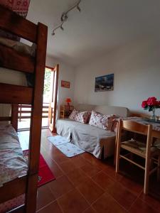 a living room with a bed and a bunk bed at Lo Scoiattolo e il Ghiro in Fiumalbo