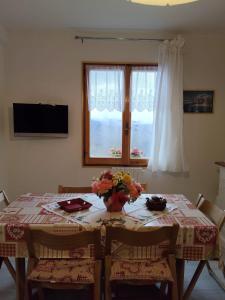 a dining room table with a vase of flowers on it at Lo Scoiattolo e il Ghiro in Fiumalbo