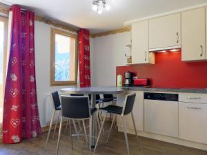 a kitchen with a table and chairs in a room at Apartment Sérac in Méribel