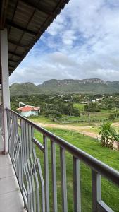 a balcony with a view of a field and mountains at Suítes FM in Cavalcante