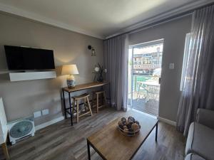 a living room with a table and a room with a window at ShipsBell 5B in St Francis Bay