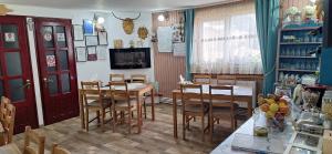 a dining room with a table and chairs at Pensiunea Floarea Dornei in Şarul Dornei