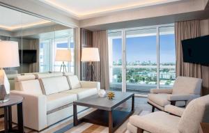 a living room with a white couch and a large window at Conrad Fort Lauderdale Beach in Fort Lauderdale