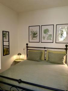 a bedroom with a bed with four pictures on the wall at Lake Como PORTO VECCHIO - Charming Lakefront Apartment in the Heart of Domaso in Domaso