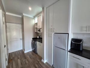 a kitchen with white cabinets and a white refrigerator at ShipsBell 5B in St Francis Bay +24 photos