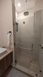 a bathroom with a glass shower with a sink at Vista Cortes 2BR 2BA Condo - Walk to the Malecon! in La Paz +46 photos