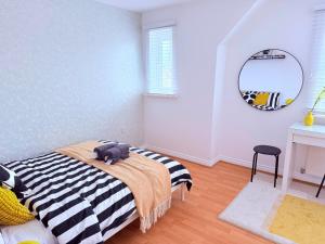 a bedroom with a bed with a black and white blanket at Spacious 4-Bed Home with Workspace in Coundon