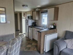a kitchen with a sink and a counter in a caravan at haggerston castle lakeside east 27 in Goswick Station