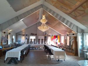 a large room with tables and chairs and a chandelier at Borgahallen The Wedding Room in Rimbo