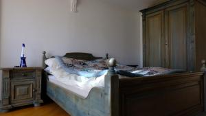 a bedroom with a bed with a wooden frame and a dresser at Rose Garden Switzerland in Avry devant Pont