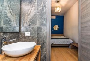 a bathroom with a white bath tub and a bedroom at Hotel Rialto Suisse in Lido di Camaiore +49 photos