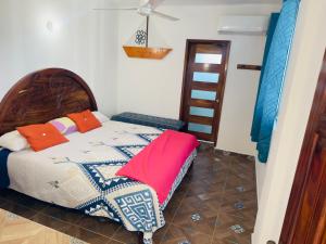 a bedroom with a bed with colorful pillows on it at Hotel Yopez in Acapulco