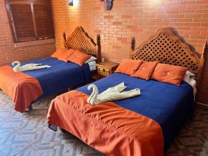 two beds in a room with two swans on them at Hotel Yopez in Acapulco +7 photos