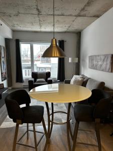 a living room with a yellow table and chairs at Condo "Imagine" - stationnement privé inclus in Quebec City
